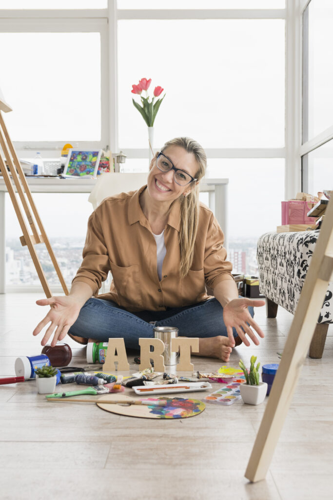 "Middle-aged woman painting at an easel in a sunlit room, with vibrant colors on the canvas and art supplies on a rustic table, symbolizing creative energy and midlife reinvention."